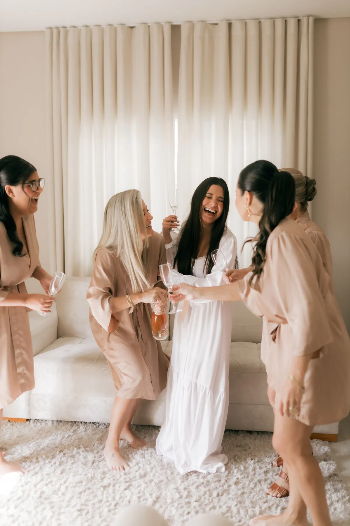 Amigas da noiva a rir enquanto se preparam para o casamento