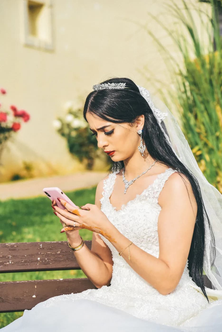 Noiva num banco do jardim com o telemóvel