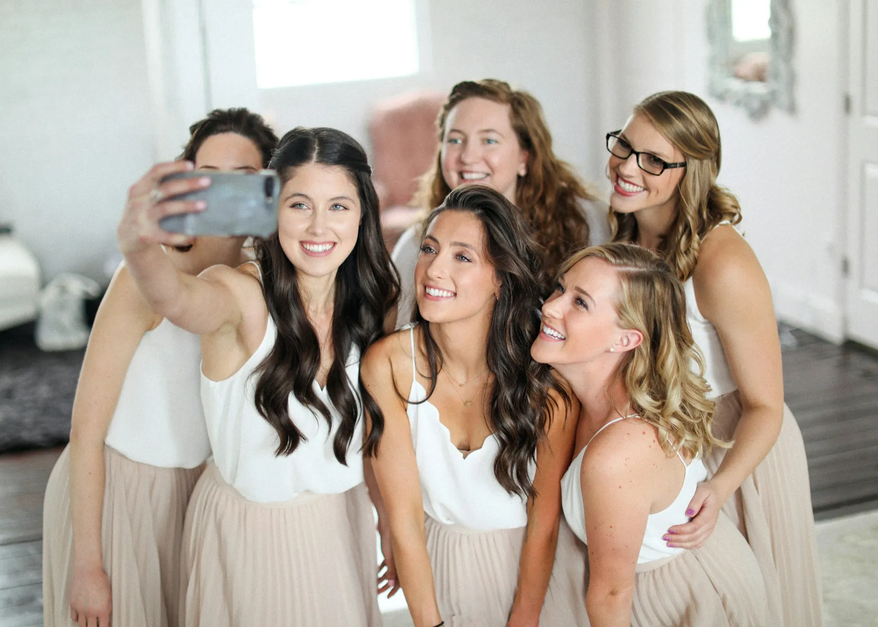 Um grupo de amigas a rir numa selfie durante um casamento